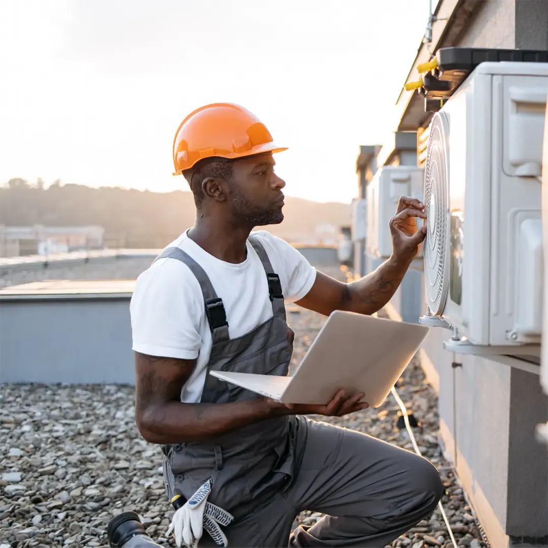 A Morgan M technician servicing a home air conditioning unit